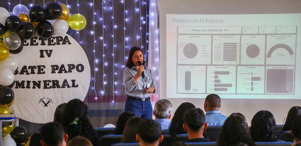 a person speaking into a microphone in front of a crowd of people