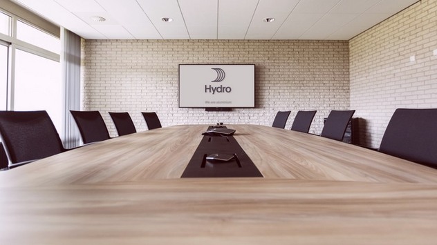 Conference room with large table, chairs and a monitor