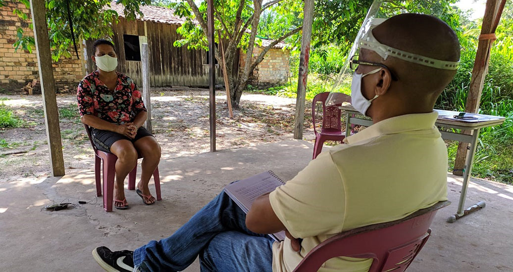 a man and woman sitting on a bench with a person in a mask